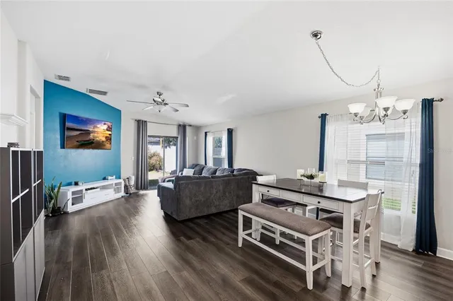 a living room with furniture a flat screen tv and wooden floor