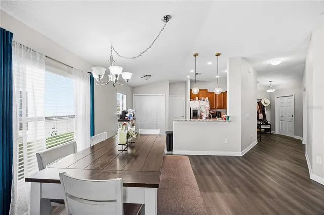 a view of a dining room and livingroom with furniture wooden floor windows
