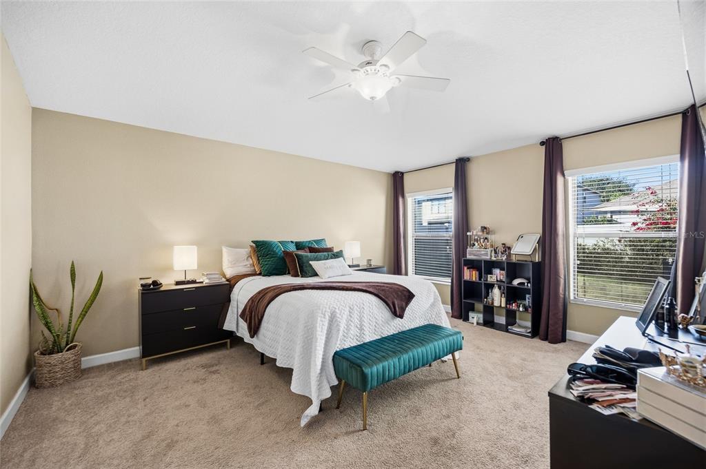 10019 Newminster Loop Ruskin, FL 33573 - Photo 16 of 34 a spacious bedroom with a bed and a chandelier