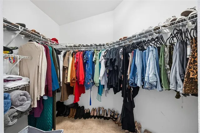 a view of walk in closet with clothes