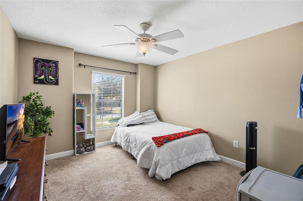 10019 Newminster Loop Ruskin, FL 33573 - Photo 23 of 34 a bedroom with a bed and a chandelier