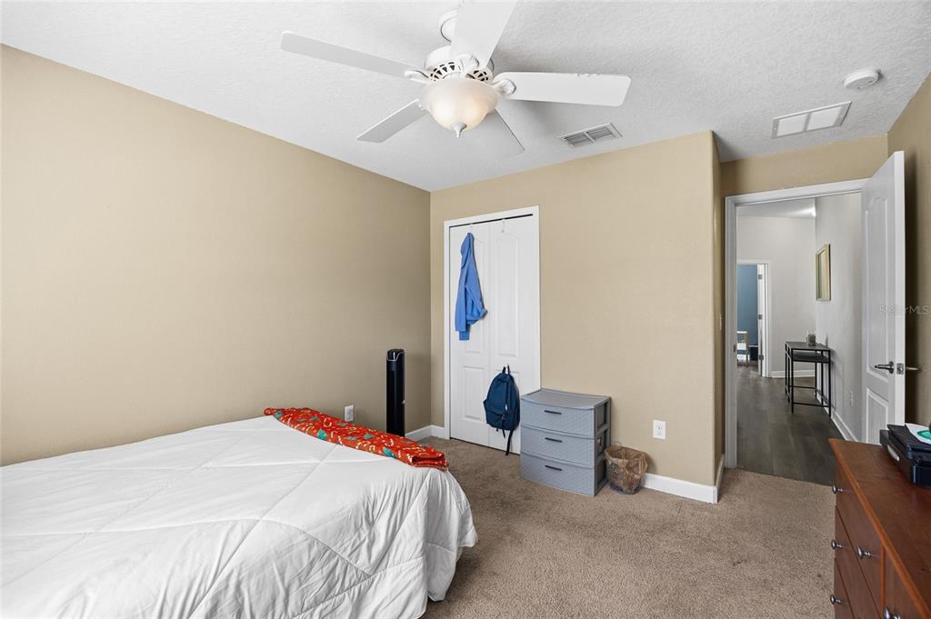 10019 Newminster Loop Ruskin, FL 33573 - Photo 24 of 34 a bedroom with a bed and a chandelier