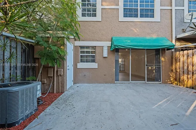 a view of a house with a backyard and barbeque grill