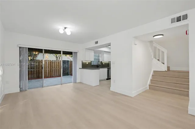 a view of a kitchen with wooden floor and a refrigerator