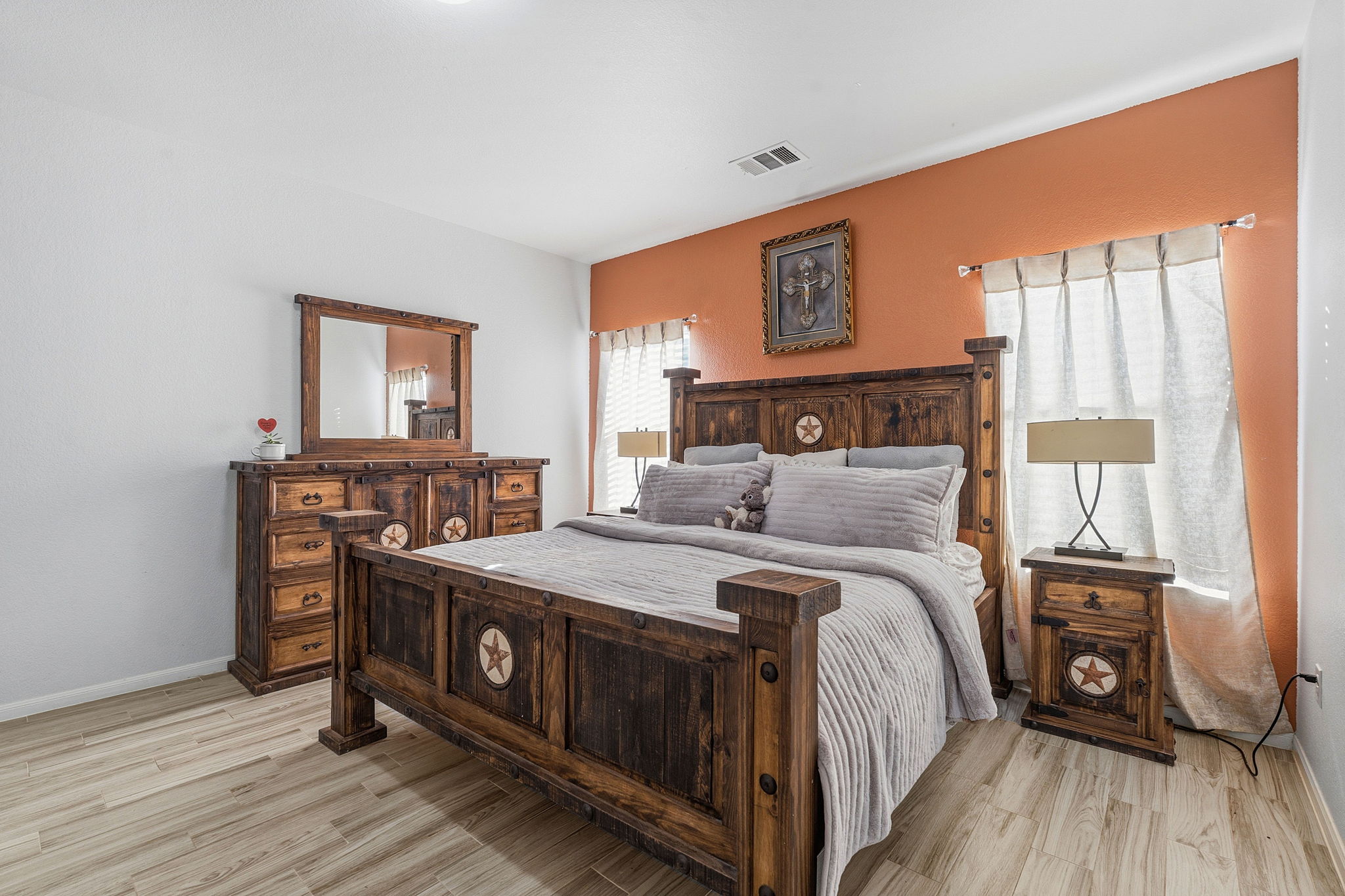 15101 Shell Bark Cove Austin, TX 78724 - Photo 22 of 26 Bedroom featuring wood-finish flooring, a ceiling-mounted light fixture, and windows with neutral-toned curtains