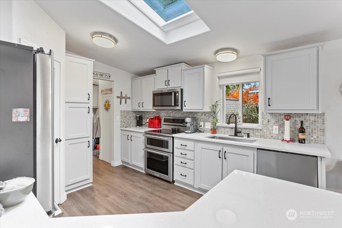 23825 15th Avenue Southeast, Unit 6 Bothell, WA 98021 - Photo 16 of 30 a kitchen with a sink a stove a refrigerator and cabinets
