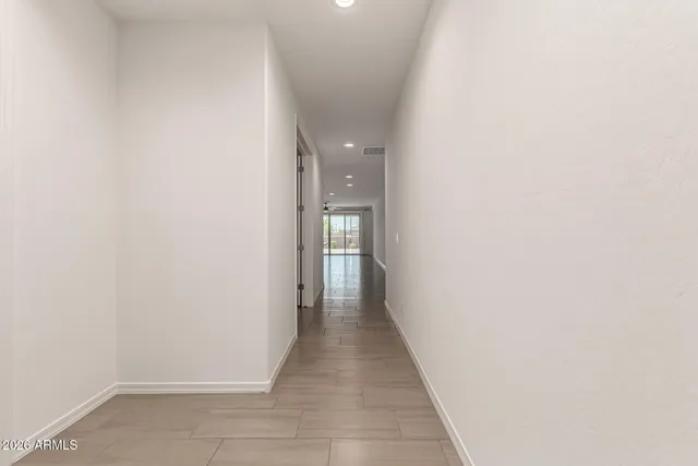 a view of a hallway with wooden floor and a bathroom