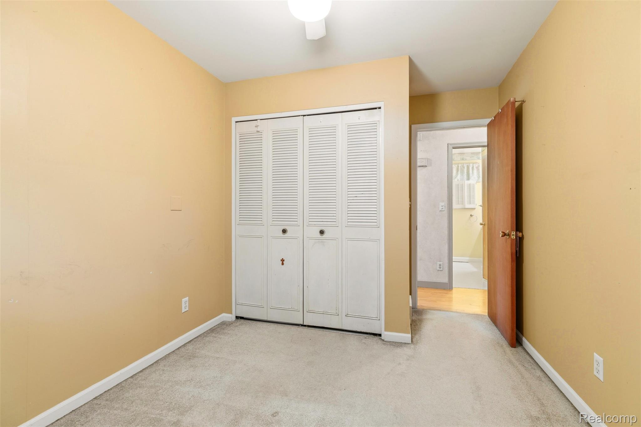 309 Windy Bluff Street Flushing, MI 48433 - Photo 13 of 32 Neutral-toned room featuring a ceiling-mounted light fixture, light-colored carpeting, and a bi-fold louvered closet