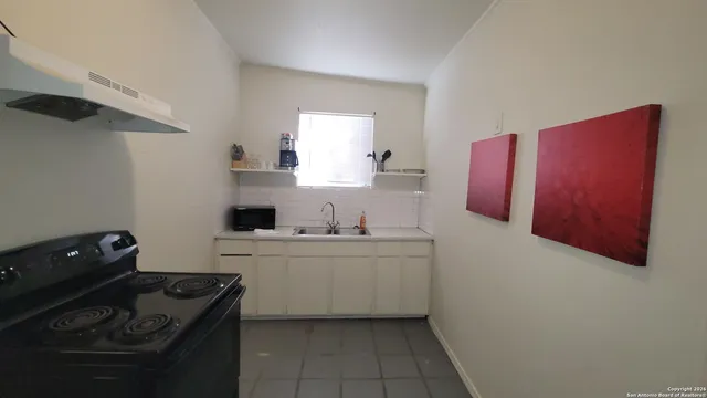 a kitchen with a sink stove and cabinets