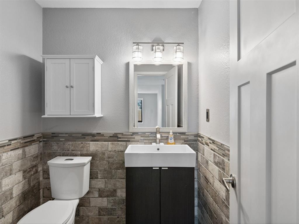 5304 Los Altos Road Fort Worth, TX 76244 - Photo 15 of 30 Half bath with tile walls, vanity, and a wainscoted wall