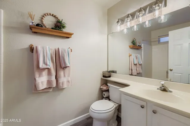 a bathroom with a sink mirror and toilet