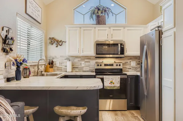 a kitchen with stainless steel appliances a stove refrigerator and a sink