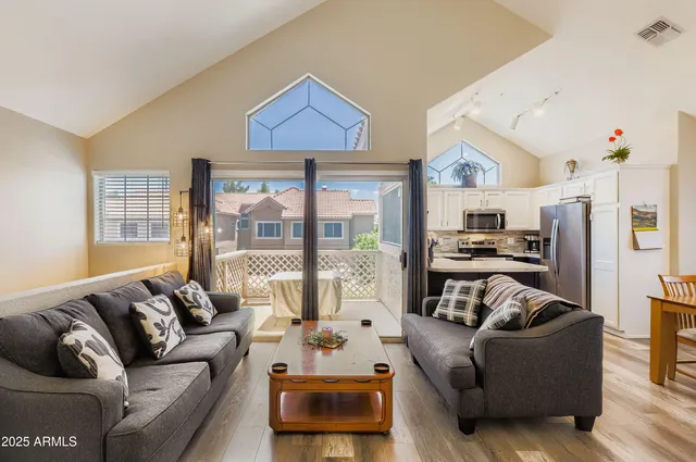 a living room with furniture a large window and a chandelier