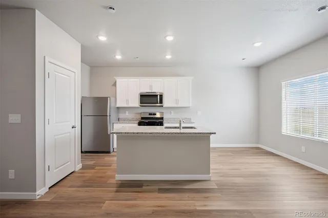 a kitchen with stainless steel appliances a refrigerator sink and microwave