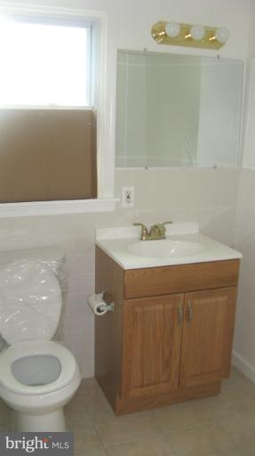 8209 Oakleigh Road Baltimore, MD 21234 - Photo 2 of 27 a bathroom with a sink a toilet and mirror