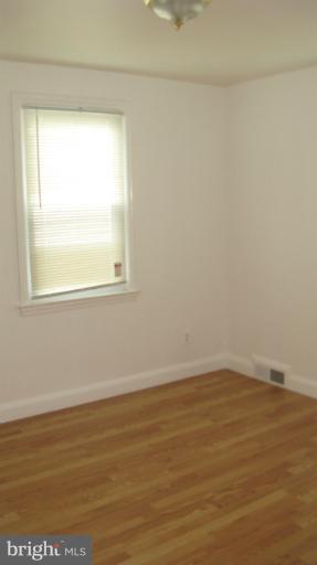 8209 Oakleigh Road Baltimore, MD 21234 - Photo 11 of 27 a view of an empty room with wooden floor and a window