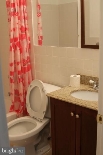 8209 Oakleigh Road Baltimore, MD 21234 - Photo 19 of 27 a bathroom with a granite countertop toilet sink and mirror