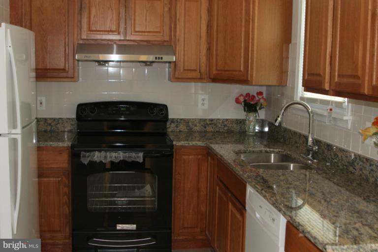 8209 Oakleigh Road Baltimore, MD 21234 - Photo 20 of 27 a kitchen with granite countertop stainless steel appliances and cabinets