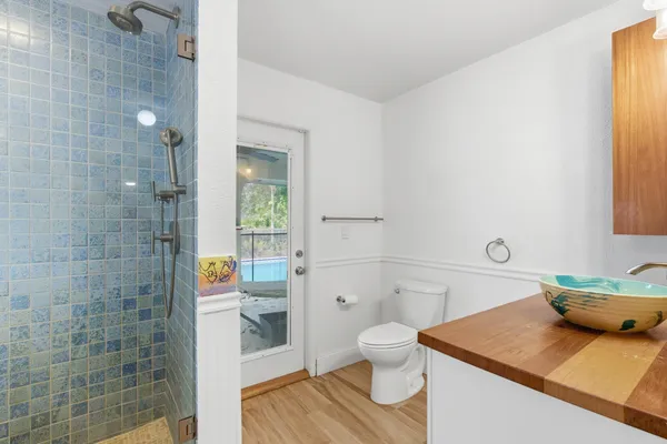 a bathroom with a granite countertop sink a toilet and shower