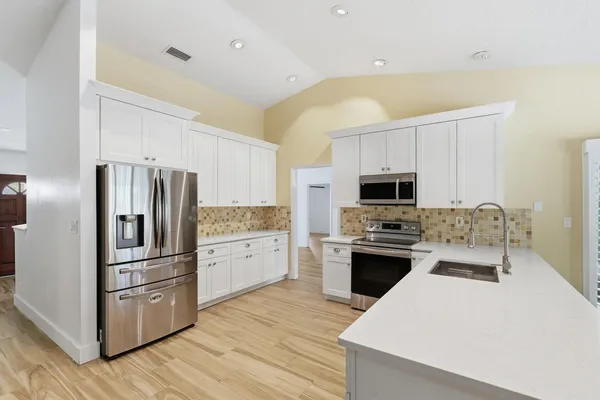 a kitchen with stainless steel appliances a refrigerator sink and microwave