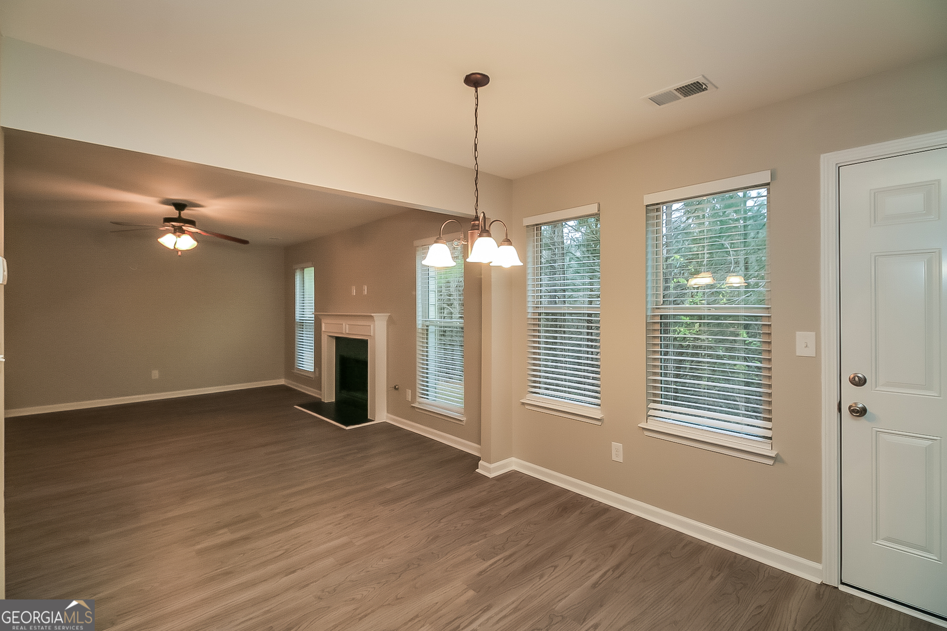 7826 Bell Tower Lane Fairburn, GA 30213 - Photo 4 of 17 a view of a room with wooden floor fireplace and windows