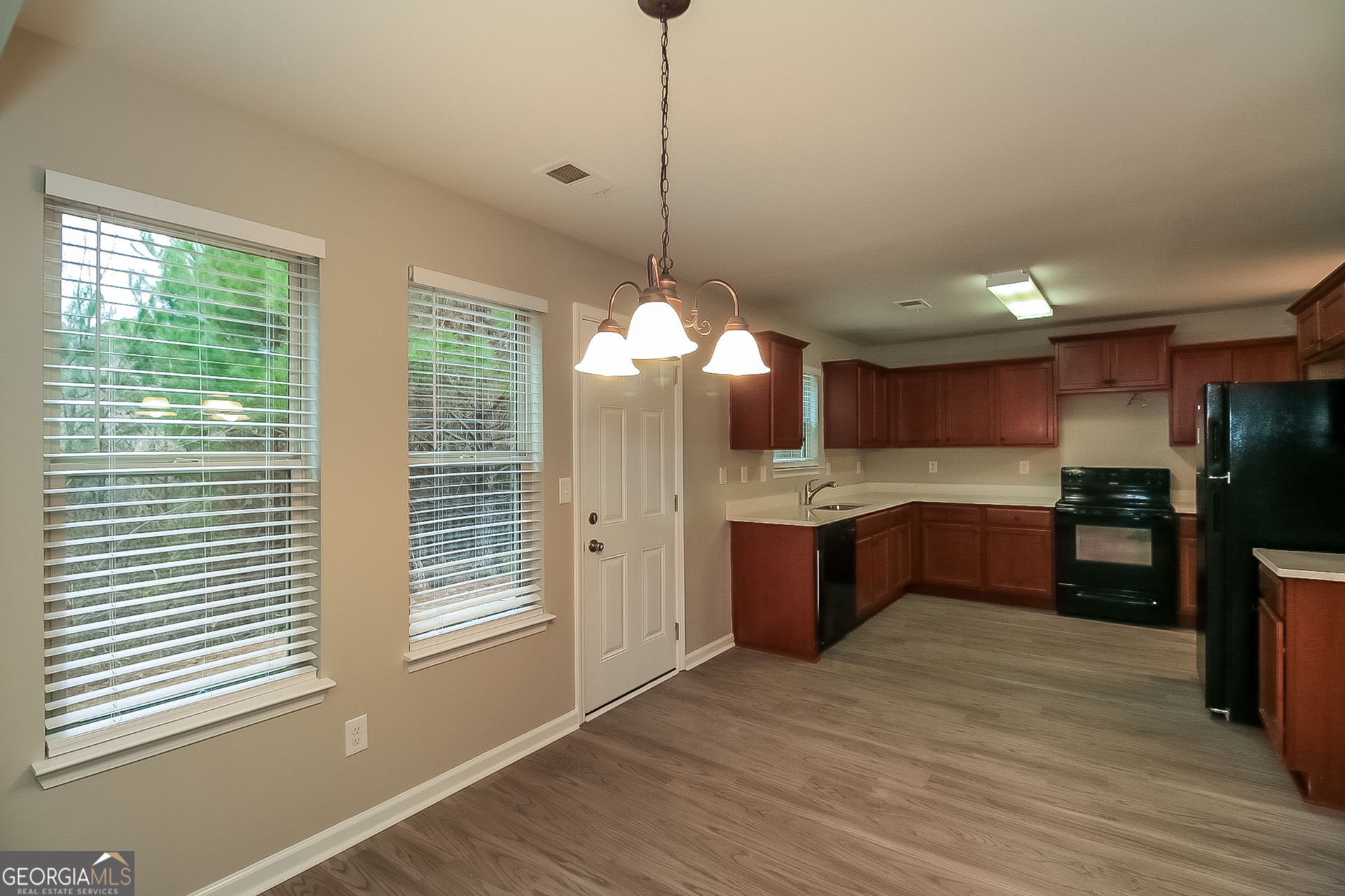 7826 Bell Tower Lane Fairburn, GA 30213 - Photo 5 of 17 a kitchen with stainless steel appliances granite countertop cabinets a window and a kitchen island