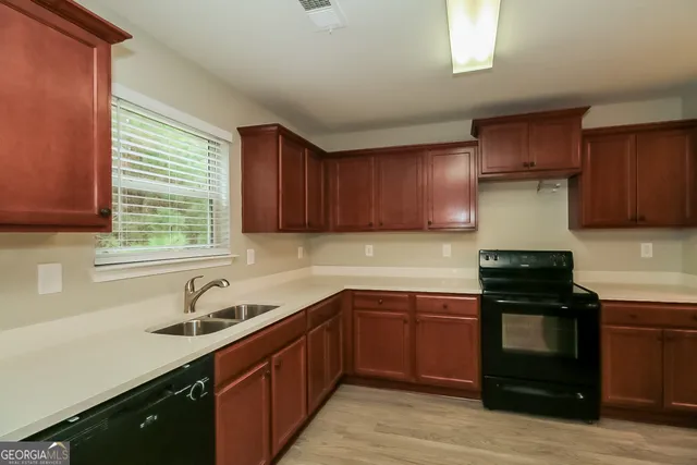 a kitchen with a sink stove and cabinets