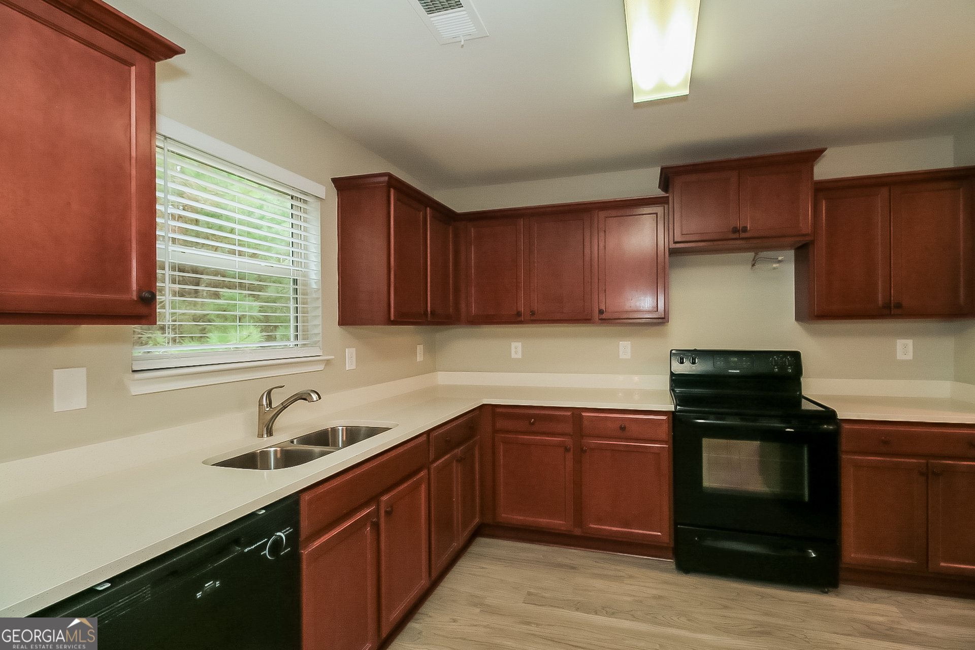 7826 Bell Tower Lane Fairburn, GA 30213 - Photo 7 of 17 a kitchen with a sink stove and cabinets