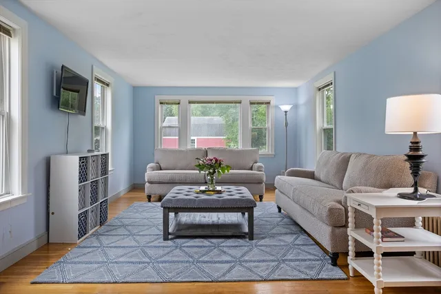 a living room with furniture a flat screen tv and a rug