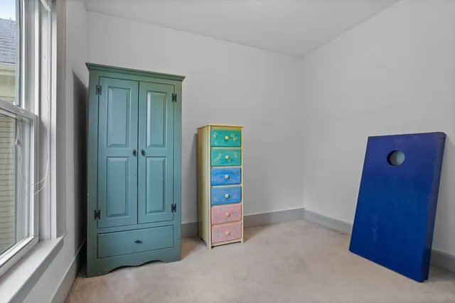 a view of an empty room with closet and windows