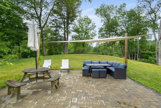 a backyard of a house with fountain table and chairs