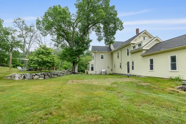 a view of a house with a big yard and a large tree