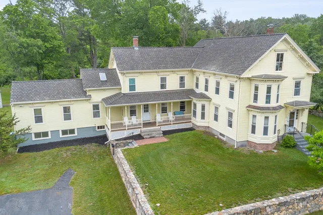 a aerial view of a house with a yard table and chairs