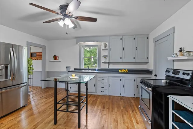 a kitchen with stainless steel appliances granite countertop a stove a sink dishwasher and cabinets with wooden floor