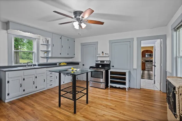 a kitchen with stainless steel appliances white cabinets and wooden floor