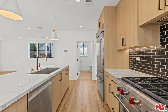 a kitchen with kitchen island granite countertop a sink stove and refrigerator
