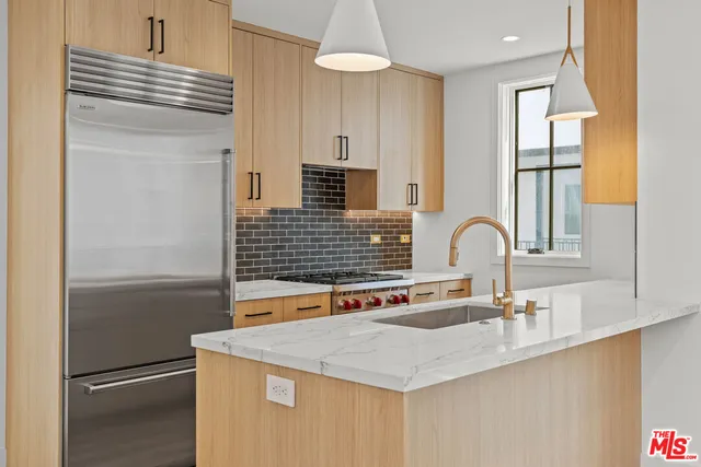 a kitchen with stainless steel appliances granite countertop a sink and a refrigerator