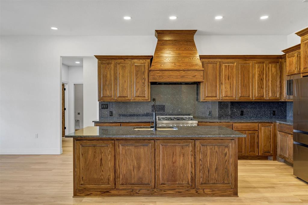 3031 Powell Cemetery Road Tolar, TX 76476 - Photo 13 of 40 a kitchen with kitchen island granite countertop a stove and a sink