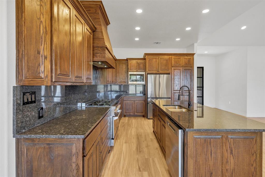 3031 Powell Cemetery Road Tolar, TX 76476 - Photo 15 of 40 a kitchen with kitchen island granite countertop a sink a counter top space and cabinets