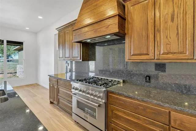 a kitchen with stainless steel appliances granite countertop a stove and a sink