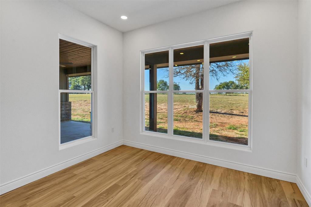 3031 Powell Cemetery Road Tolar, TX 76476 - Photo 20 of 40 an empty room with wooden floor and windows