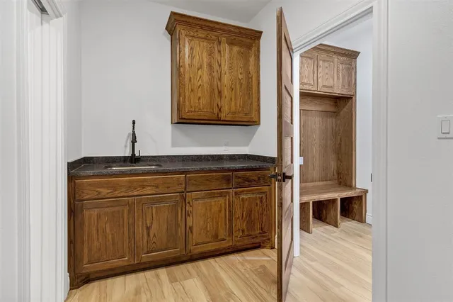 a view of a hallway with wooden floor and cabinet
