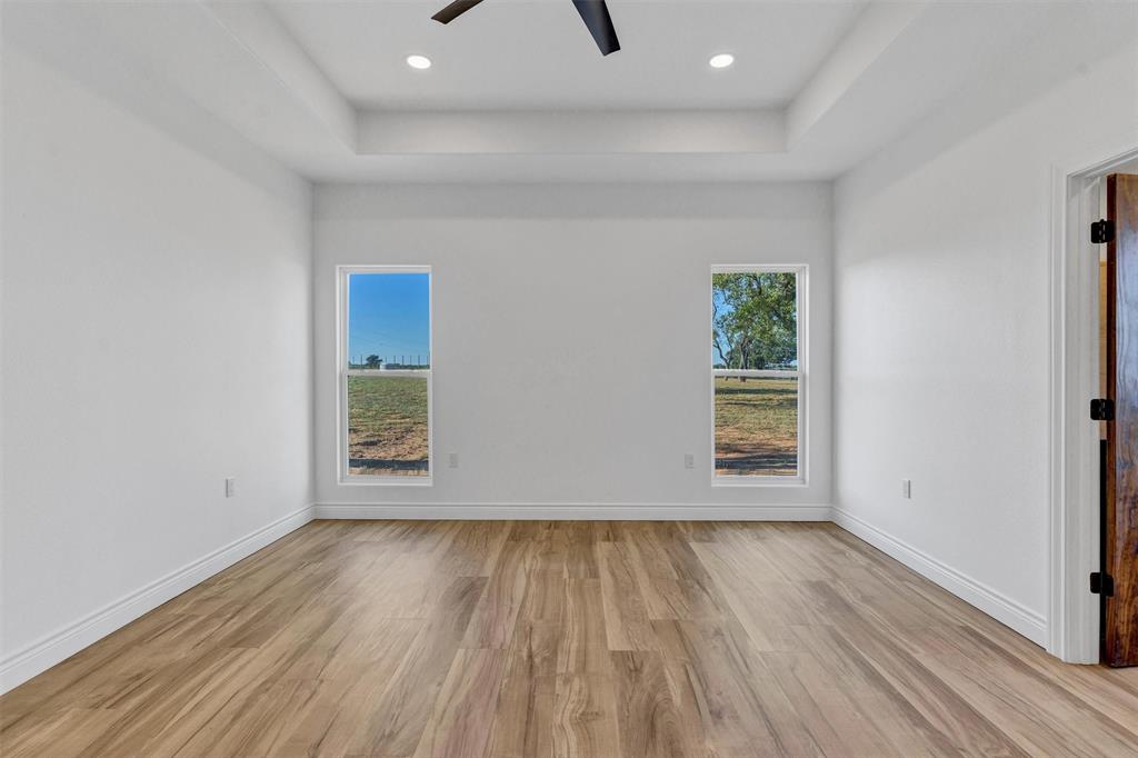 3031 Powell Cemetery Road Tolar, TX 76476 - Photo 25 of 40 an empty room with wooden floor and windows