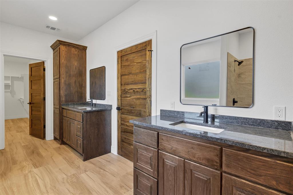 3031 Powell Cemetery Road Tolar, TX 76476 - Photo 27 of 40 a bathroom with a double vanity sink and a mirror
