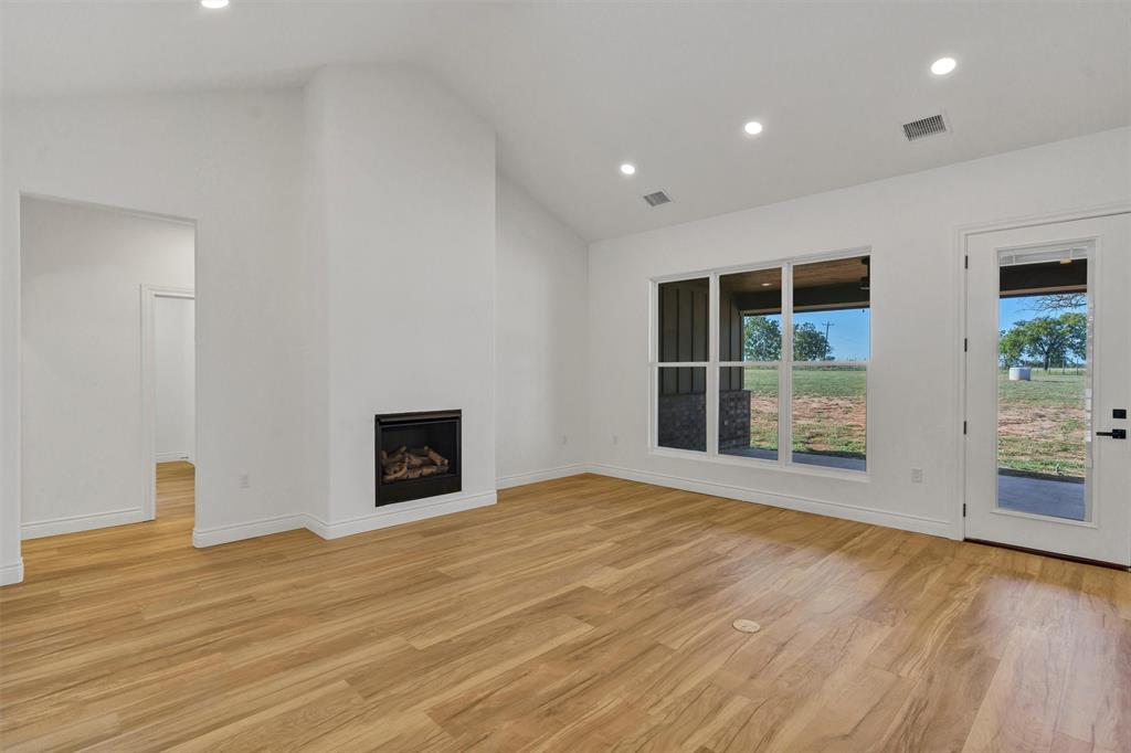 3031 Powell Cemetery Road Tolar, TX 76476 - Photo 8 of 40 a view of an empty room with a window and wooden floor