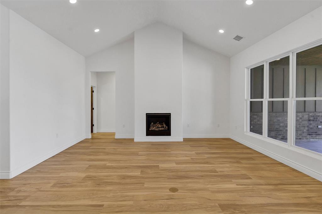 3031 Powell Cemetery Road Tolar, TX 76476 - Photo 9 of 40 a view of an empty room with wooden floor and a window