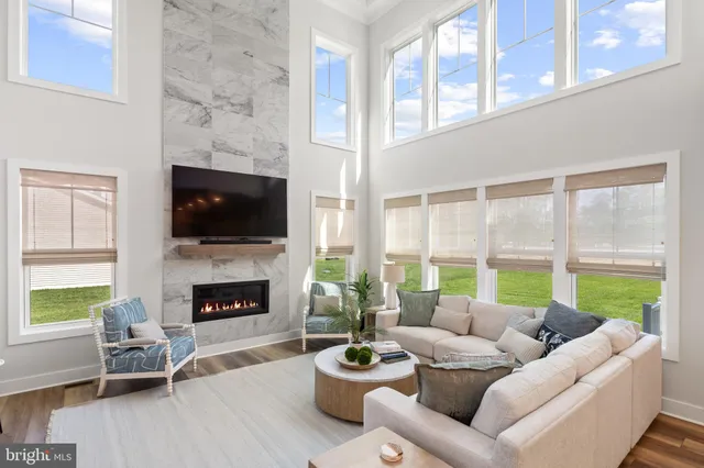 a living room with furniture fireplace and a large window