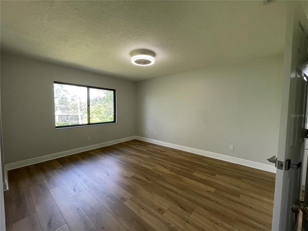 5395 Vineland Road, Unit S Orlando, FL 32811 - Photo 18 of 30 a view of an empty room with wooden floor and a window