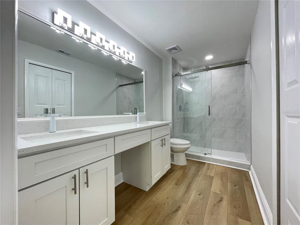 5395 Vineland Road, Unit S Orlando, FL 32811 - Photo 19 of 30 a bathroom with a double vanity sink toilet and shower