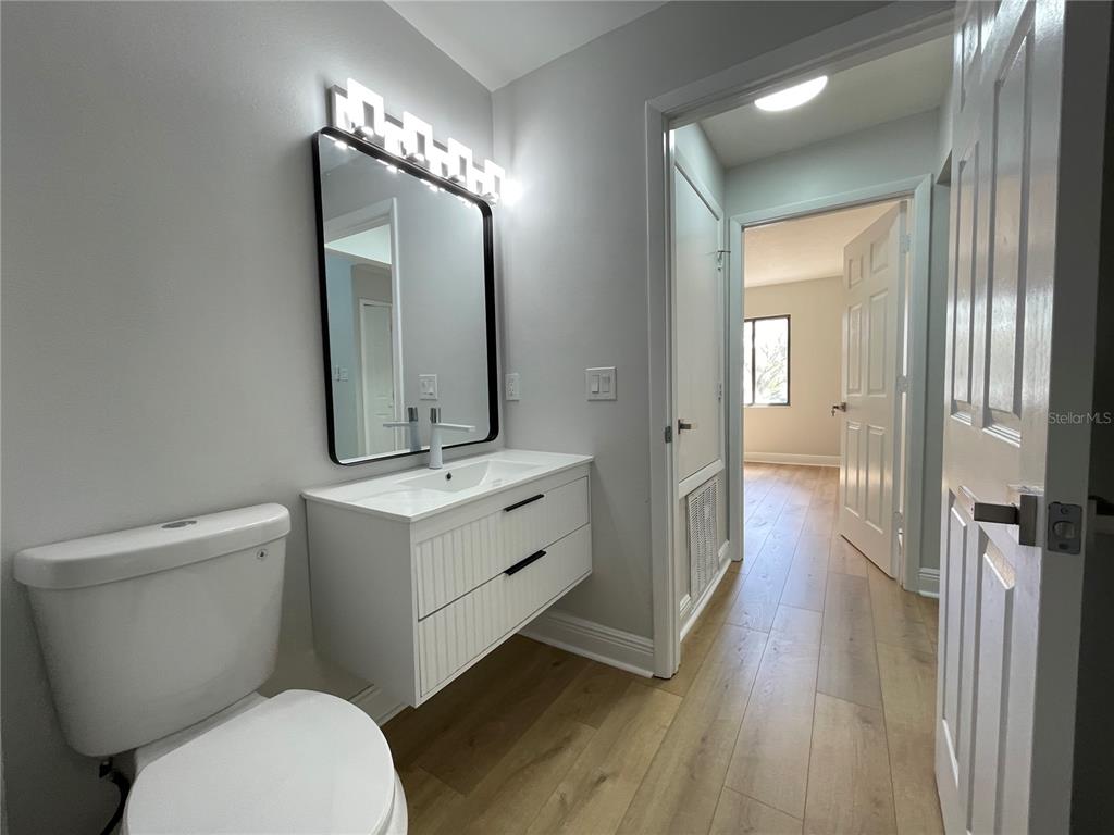 5395 Vineland Road, Unit S Orlando, FL 32811 - Photo 29 of 30 a bathroom with a toilet a sink and mirror